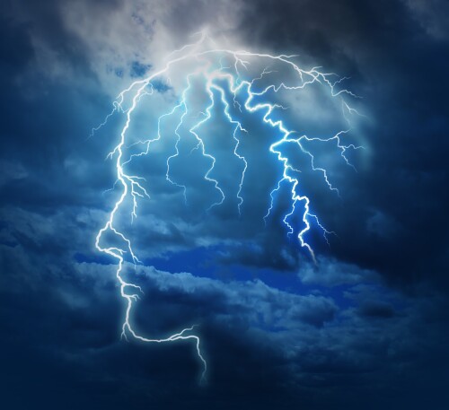 Powerful intelligence with an electric lightning bolt strike in the shape of a human head illuminated on a storm cloud night sky as a brain function neurology health care symbol.